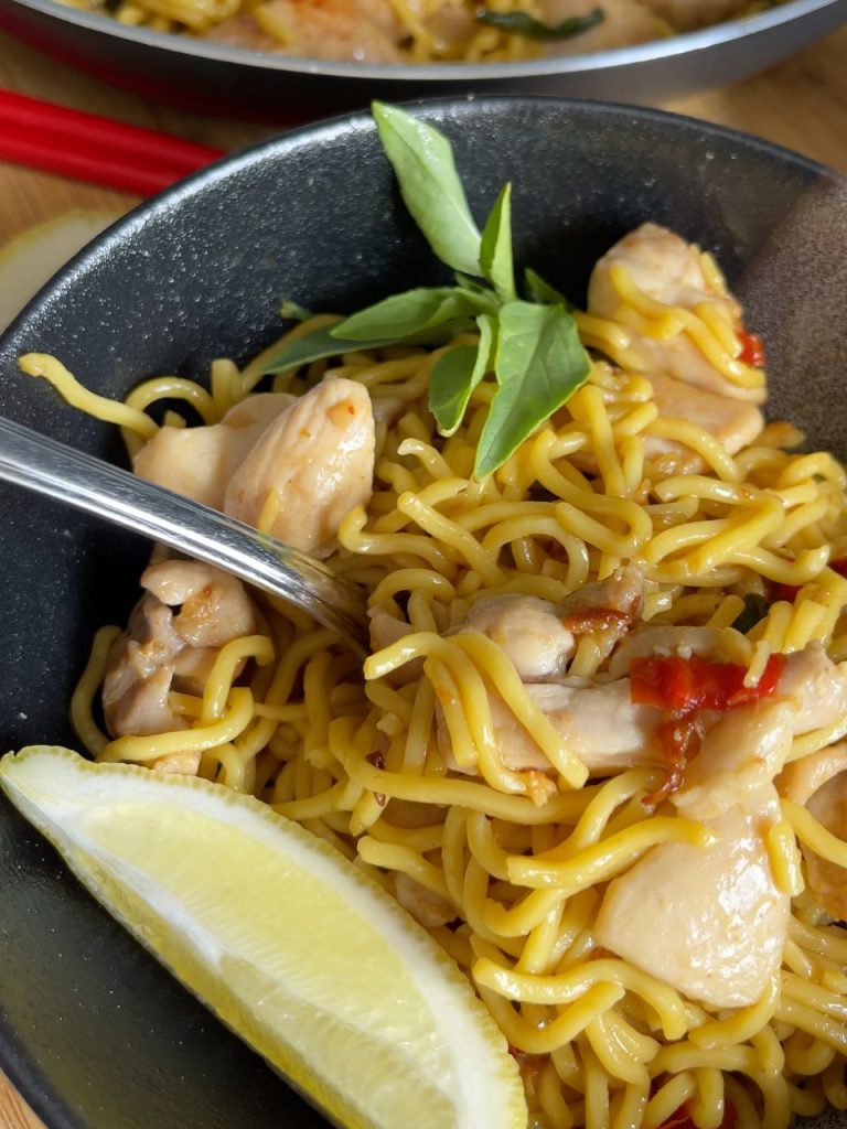 Chilli chicken Hokkien noodles and tender chicken pieces scooped on a fork