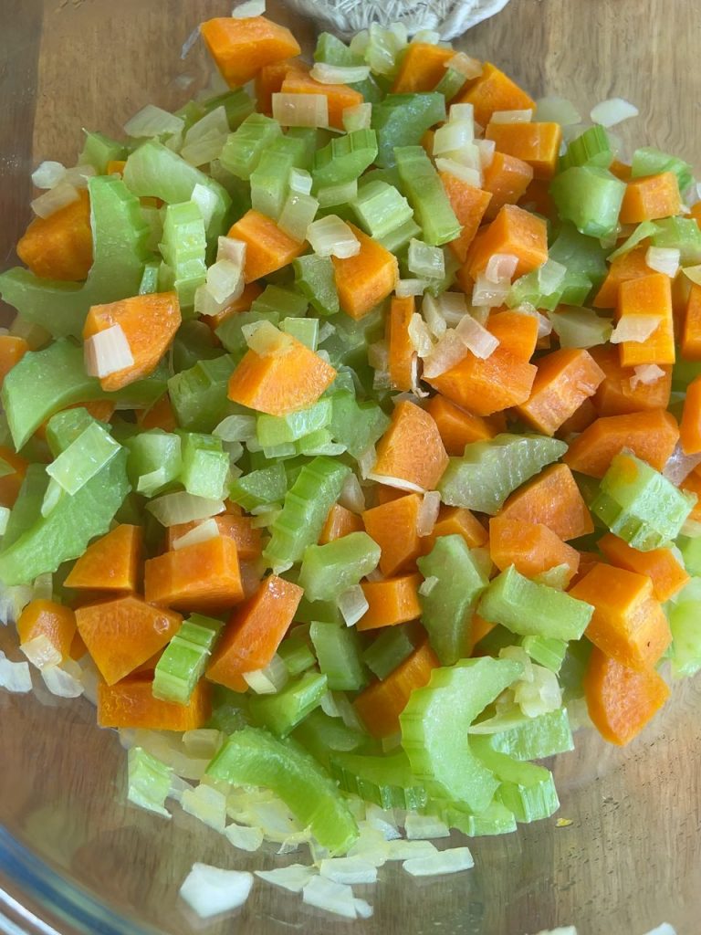 Chopped onions, carrots, and celery microwaved in butter in a glass bowl