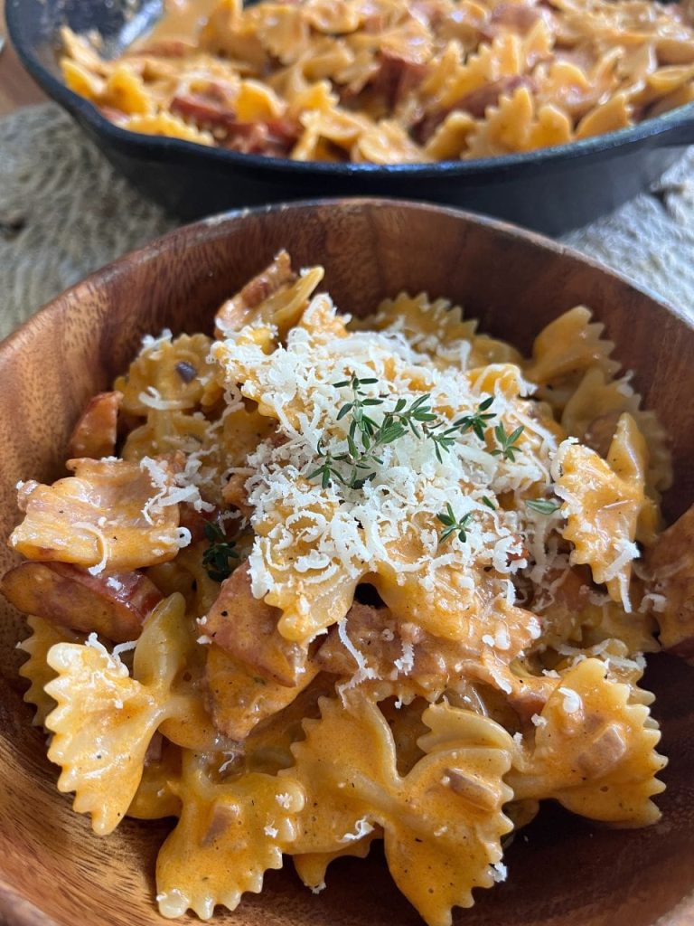 Creamy chorizo and bacon pasta plated with parmesan and parsley garnish