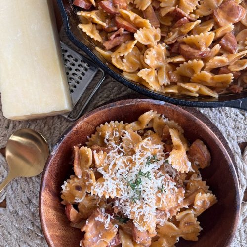 Farfalle pasta coated in a creamy chorizo and bacon sauce in the pan