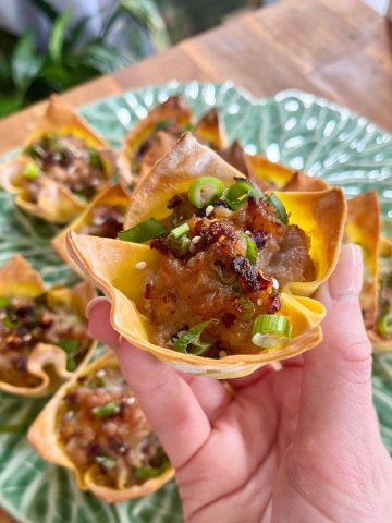 Close-up of crispy pork dumpling cups on a plate, showing the golden, crunchy edges and juicy filling