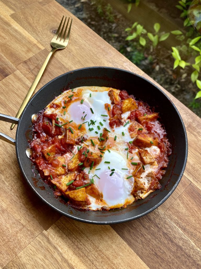 Overhead shot of the breakfast skillet, showcasing golden potatoes, rich tomatoes, and soft eggs