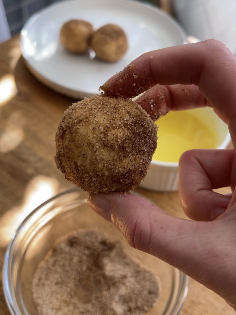 Close-up of donut bites showing the crispy, golden exterior dusted with cinnamon sugar
