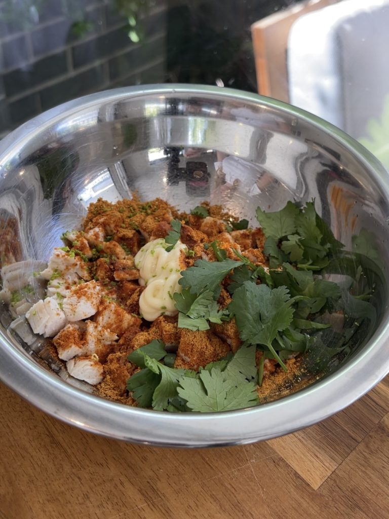 Cooked chicken breast cubed and mixed in a bowl with chipotle seasoning, lime zest, coriander, and Kewpie mayo