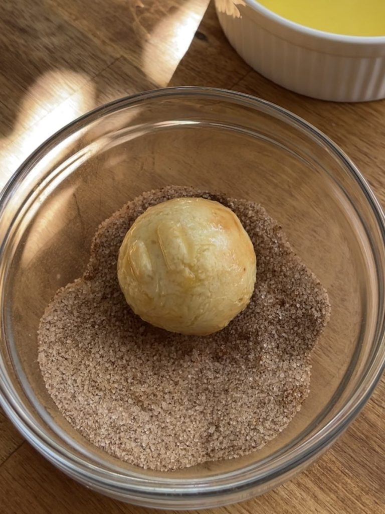 Donut bites rolled in a cinnamon sugar mixture, evenly coated and ready to serve