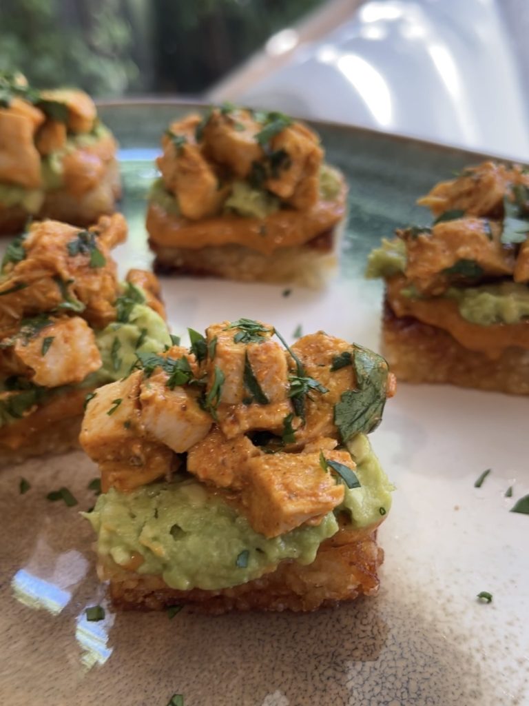 Golden rice squares stacked with toppings on a colourful platter