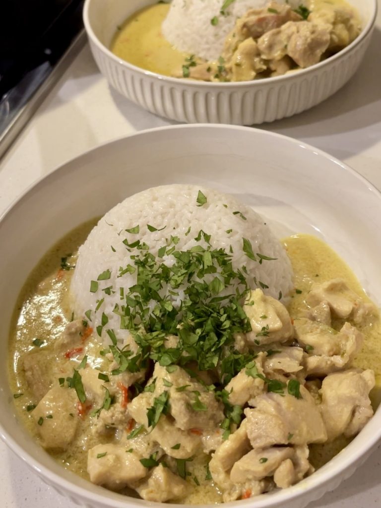 Mild Sri Lankan chicken curry served with basmati rice in a white bowl, garnished with fresh coriander