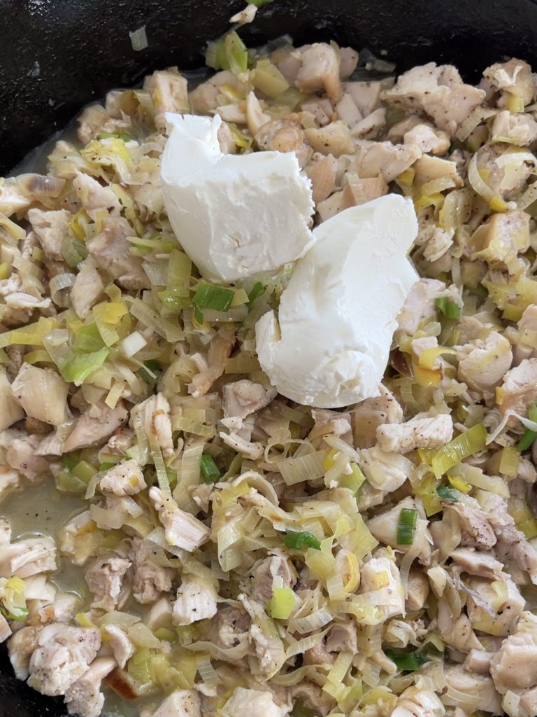 Cream cheese and egg waiting to be stirred into the chicken mixture off heat, creating a creamy filling for the tart