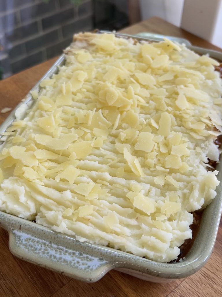 Shepherd's pie topped with parmesan ready to be baked