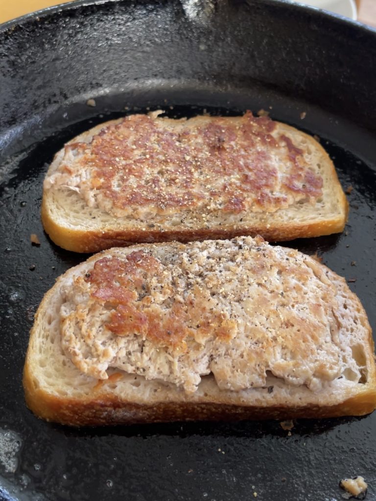 Sausage and egg sandwich in progress, Pork-covered bread frying until golden brown